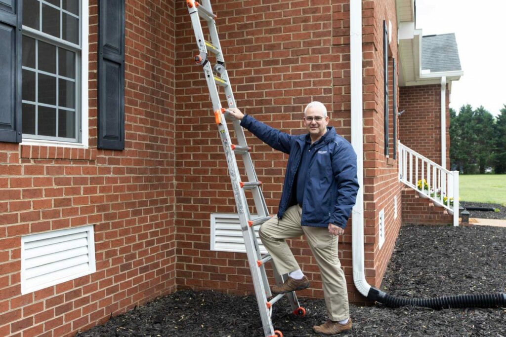Peter Bunai stepping up a ladder